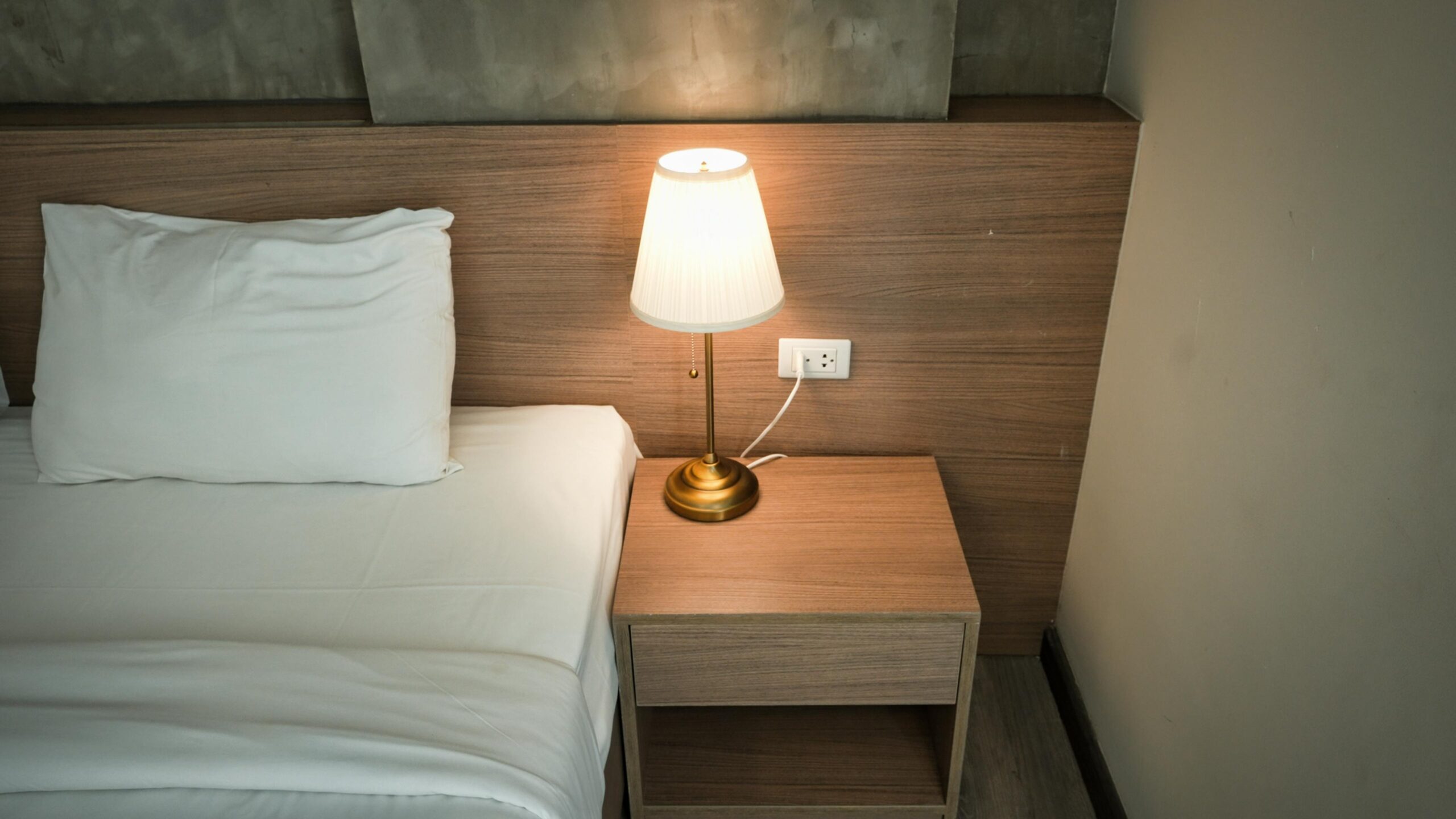 brass bedside lamp with a slim, understated profile for relaxed lighting
