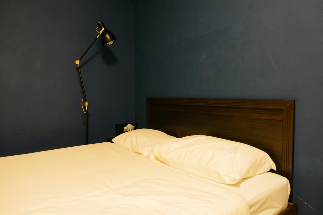 bedroom corner illuminated by floor lamp instead of ceiling light